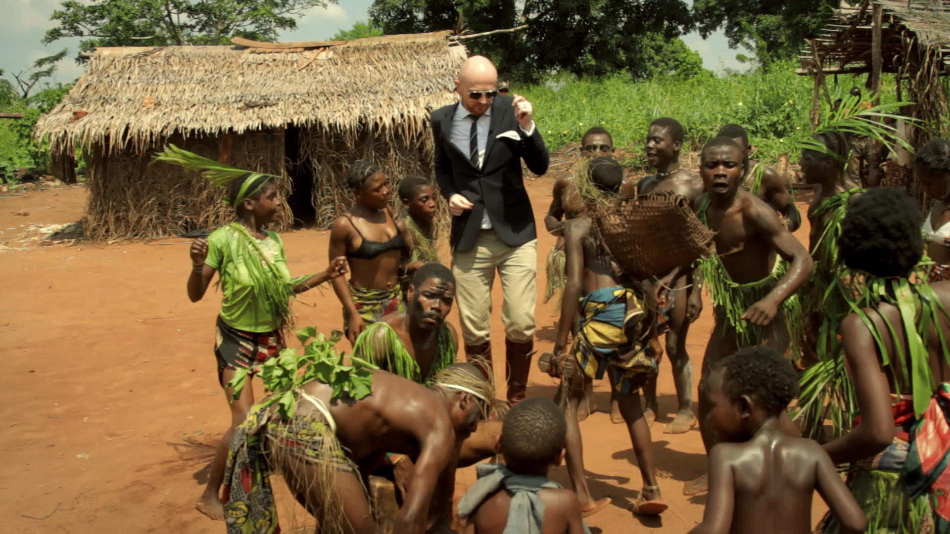 A tourist enjoys traditional dance of the Mbuti/Pygmies people on a Congo cultural safari.