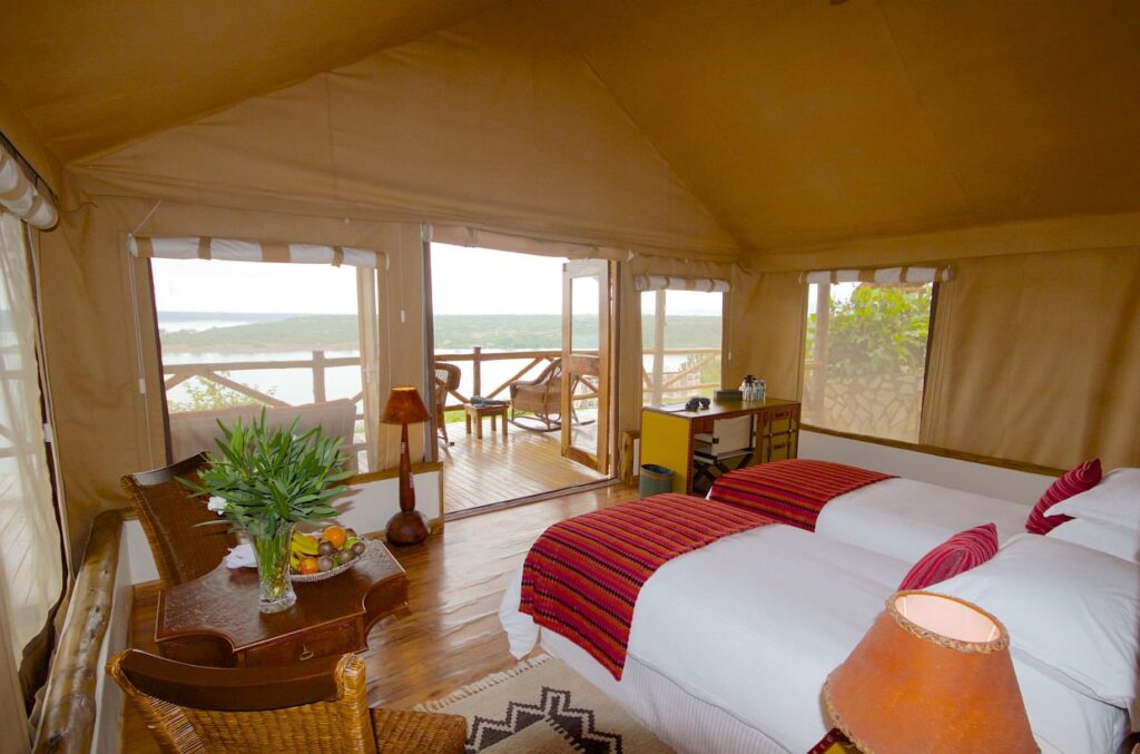 Enganzi Game Lodge is a charming midrange safari lodge located on the edge of Queen Elizabeth National Park, offering stunning views over the savannah and surrounding crater lakes. The lodge features comfortable cottages with en-suite bathrooms, private verandas, and tasteful African-inspired décor. Guests enjoy a peaceful atmosphere, excellent service, and delicious meals prepared with fresh local ingredients. Its strategic location makes it ideal for game drives and easy access to the Kazinga Channel. Enganzi Game Lodge provides a perfect balance of comfort, scenery, and value, making it a popular choice for midrange safaris in Uganda.