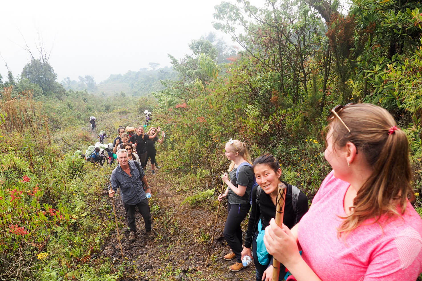 Tourists hiking Mount Nyiragongo while experiencing one of Africa’s most thrilling adventures as they climb through volcanic forests and rugged lava trails toward the world’s largest active lava lake. The challenging hike rewards travelers with breathtaking summit views, glowing lava at night, dramatic volcanic scenery, and unforgettable moments inside Virunga National Park.