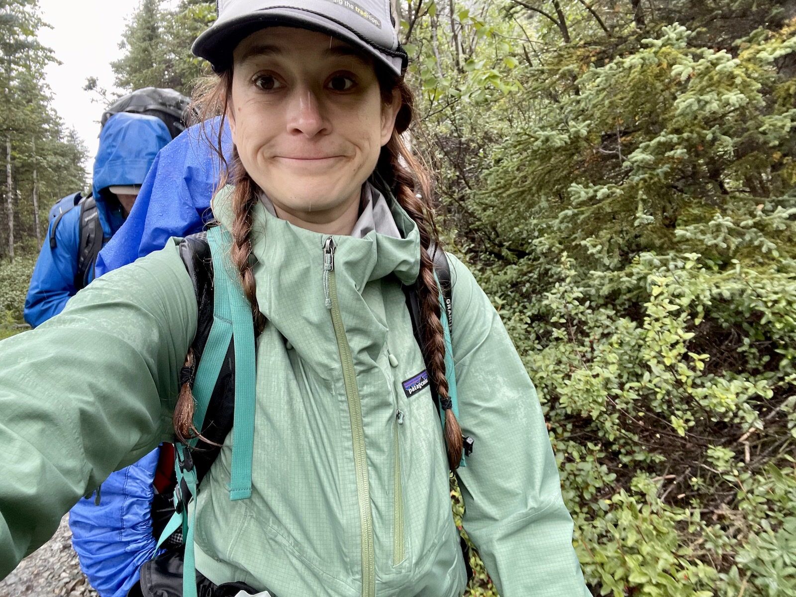 A Tourist wearing rain gear during gorilla trekking in Congo’s rainforest, carrying a waterproof backpack and hiking through muddy forest trails. Rain gear is an essential item in a Congo Safari Packing List because it protects travelers from sudden tropical rainfall, keeps clothing dry, and improves comfort during trekking and outdoor safari adventures.