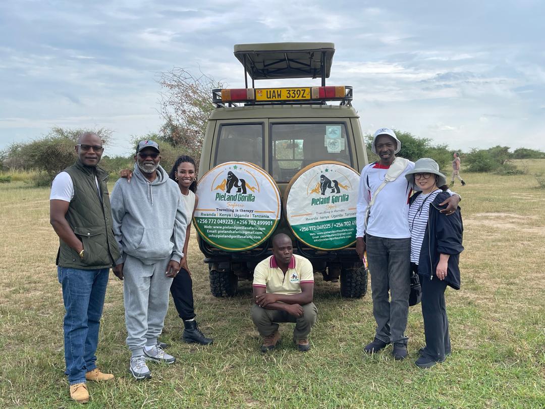 Tourists take a photo with the guide from Pialand Gorilla Safaris on an adventure in Africa.