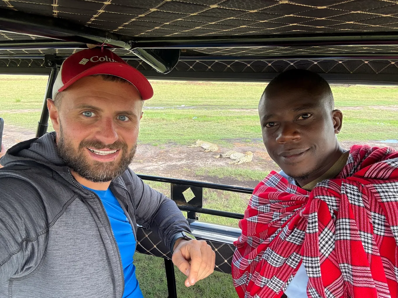 A Sign Language Safari Guide in Uganda with a tourist on a game drive in Queen Elizabeth National Park with Pieland Gorilla Safaris.