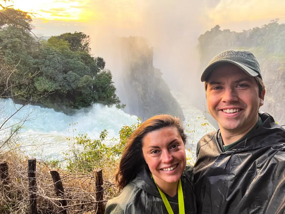 A couple standing at Victoria Falls enjoys breathtaking views of the powerful Zambezi River during their romantic holiday organized by Pieland Gorilla Safaris. Surrounded by rising mist, dramatic cliffs, lush vegetation, and the thunderous sound of cascading water, the couple shares a memorable moment in one of Africa’s most spectacular natural settings. The scenic viewpoints provide a beautiful backdrop for romantic photographs while allowing them to appreciate the immense scale of the falls. Combined with sunset cruises, luxury accommodation, wildlife experiences, and private transfers, Victoria Falls creates an unforgettable destination for couples seeking adventure, relaxation, and romance in Southern Africa.