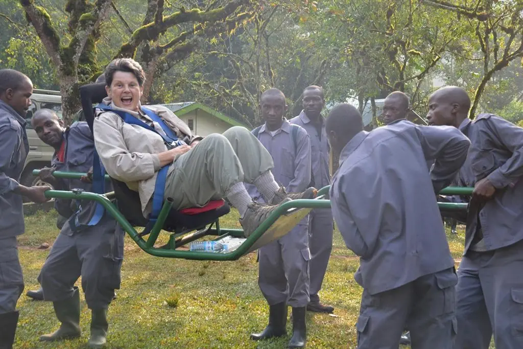 Gorilla trekking on a sedan chair offers travelers with limited mobility an assisted way to experience mountain gorillas in Uganda or Rwanda. The traveler is seated securely in a specially designed carrying chair and supported along the forest trail by a coordinated team of experienced porters. This can reduce the physical strain of steep slopes, muddy paths, roots, and uneven terrain. The experience still follows normal gorilla trekking procedures, including ranger guidance, briefing, and wildlife rules. Sedan-chair assistance should be arranged in advance, especially for senior travelers or visitors with mobility challenges who require additional support during their gorilla trekking adventure.