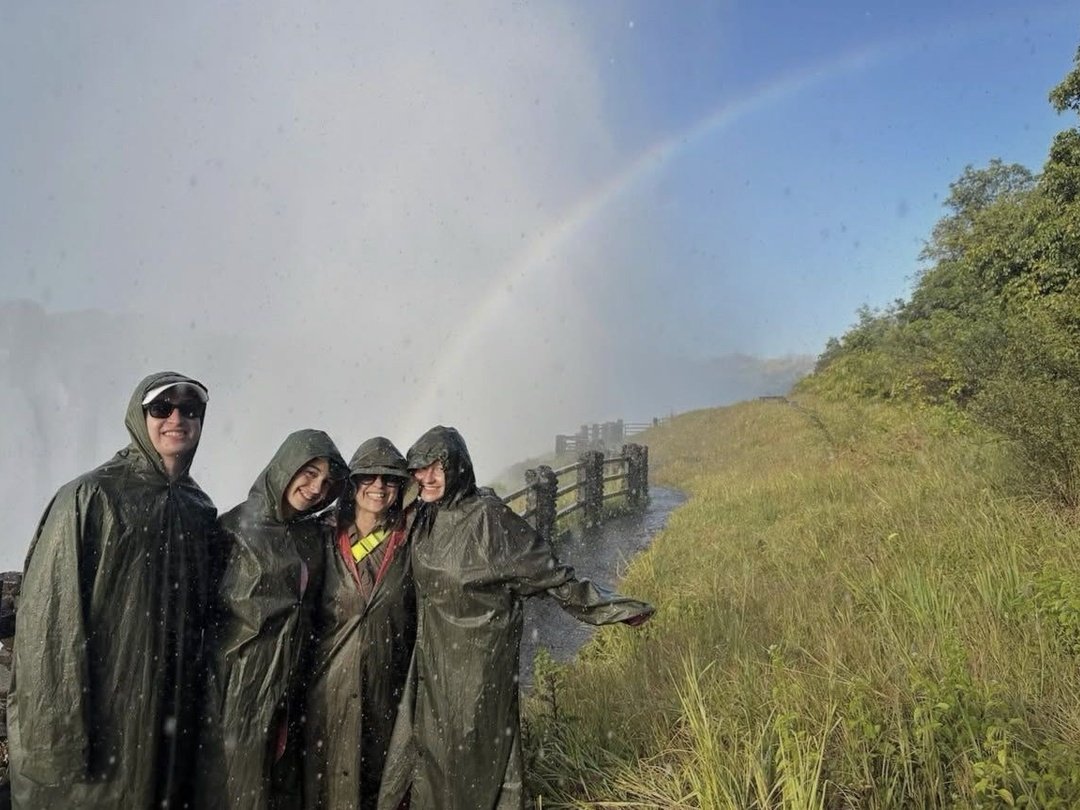 Tourists enjoyed a refreshing walk to Victoria Falls during their safari with Pieland Gorilla Safaris, following scenic pathways surrounded by lush vegetation and the powerful sound of cascading water. As they approached the viewpoints, rising mist filled the air and colorful rainbows appeared above the dramatic gorge. Wearing rain protection, the travelers experienced the impressive force of the falls from close range while stopping at different viewpoints for photographs and sightseeing. The guided walk offered an exciting way to appreciate the beauty, scale, and atmosphere of Victoria Falls, creating a memorable highlight during their Southern African safari adventure.