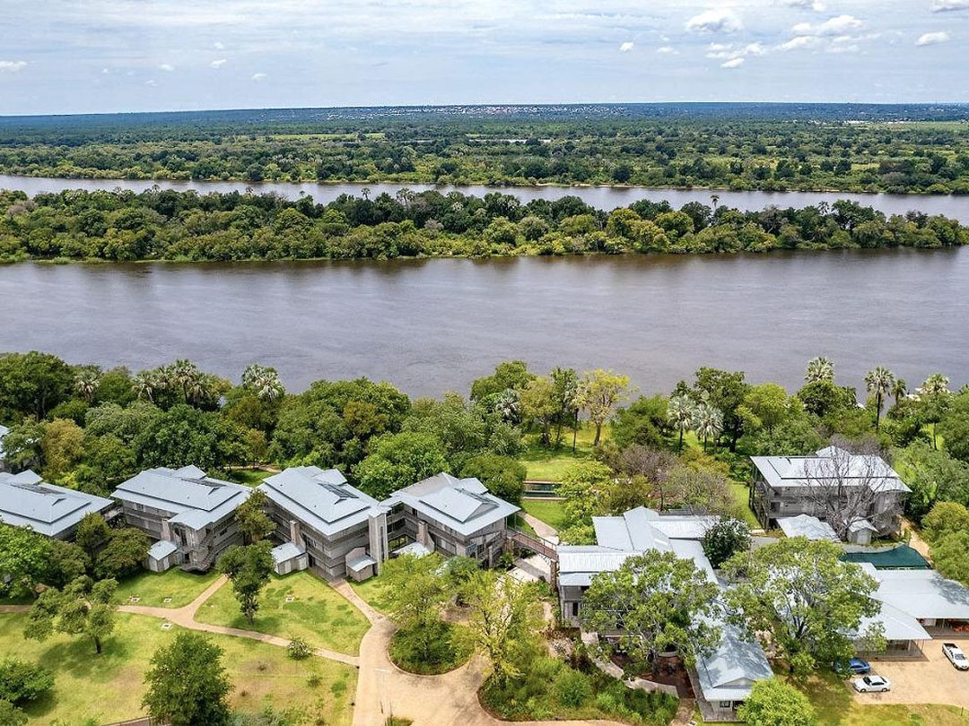 Palm River Hotel is a luxurious riverfront accommodation near Victoria Falls, offering travelers a peaceful setting along the banks of the Zambezi River. The property combines elegant rooms, beautiful gardens and a relaxed atmosphere, making it especially suitable for couples, honeymooners, families and luxury safari travelers. Guests can enjoy river views, comfortable facilities and easy access to major Victoria Falls experiences while returning to a quiet retreat after sightseeing. Pieland Gorilla Safaris can include Palm River Hotel in a customized luxury Victoria Falls safari package together with guided waterfall tours, sunset cruises, helicopter flights and wildlife extensions to nearby national parks.