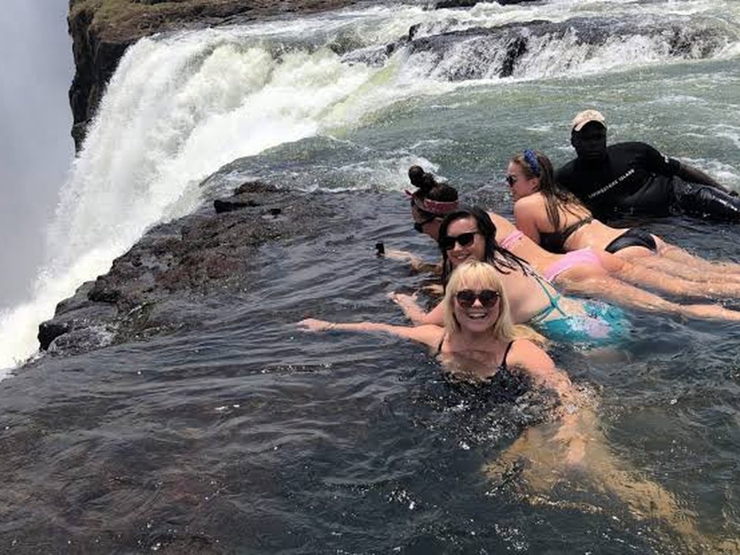 Tourists enjoy an unforgettable experience at Devil’s Pool during their 4 Days Victoria Falls and Chobe Safari, taking in spectacular views from the edge of the mighty Victoria Falls. Surrounded by rushing water, dramatic cliffs, and rising mist, the experience offers a thrilling perspective of the Zambezi River as it plunges into the gorge below. Guests can relax in the natural rock pool while admiring the breathtaking scenery and capturing memorable photographs. Devil’s Pool adds an adventurous highlight to the safari and is especially rewarding for travelers seeking unique views, excitement, and a close connection with Victoria Falls.