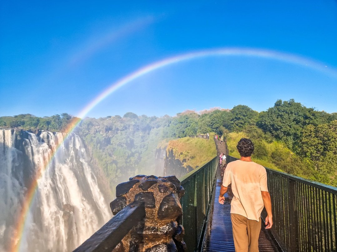A tourist walks along the scenic pathways to view Victoria Falls, enjoying breathtaking perspectives of one of Africa’s most spectacular natural wonders. The powerful Zambezi River plunges dramatically into the gorge, creating refreshing mist, spectacular rainbows and unforgettable scenery. As the visitor explores the viewpoints, they can appreciate the immense beauty and natural power of the falls while capturing memorable photographs. The experience provides a wonderful opportunity to discover Victoria Falls from different viewpoints, making it an exciting highlight of a Southern African safari adventure.