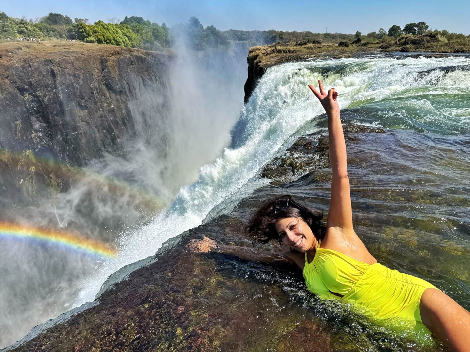 A tourist at Devil’s Pool enjoys an unforgettable view of Victoria Falls from the Zambian side on a safari organized by Pieland Gorilla Safaris. Surrounded by the powerful flow of the Zambezi River, the traveler experiences the dramatic edge of the falls while looking across the deep gorge, rising mist, and spectacular surrounding scenery. The natural rock pool offers a unique perspective of Victoria Falls and creates excellent opportunities for memorable photographs. With professional guidance and careful attention to safety, the experience combines adventure, breathtaking landscapes, and the thrill of standing beside one of Africa’s most remarkable natural attractions.