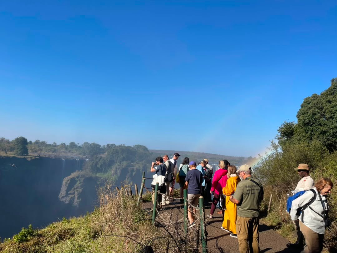Travelers standing near Victoria Falls on the Zimbabwean side enjoy spectacular views of the mighty Zambezi River as it plunges into the deep gorge below on a safari to Victoria Falls with Pieland Gorilla Safaris. From the scenic viewpoints, visitors can admire the powerful curtain of water, rising mist, colorful rainbows, and lush rainforest surrounding the falls. The Zimbabwean side offers some of the most impressive panoramic perspectives, making it ideal for photography and sightseeing. The thunderous sound and refreshing spray create an unforgettable atmosphere, turning the visit into one of the most memorable experiences of a Southern African safari.