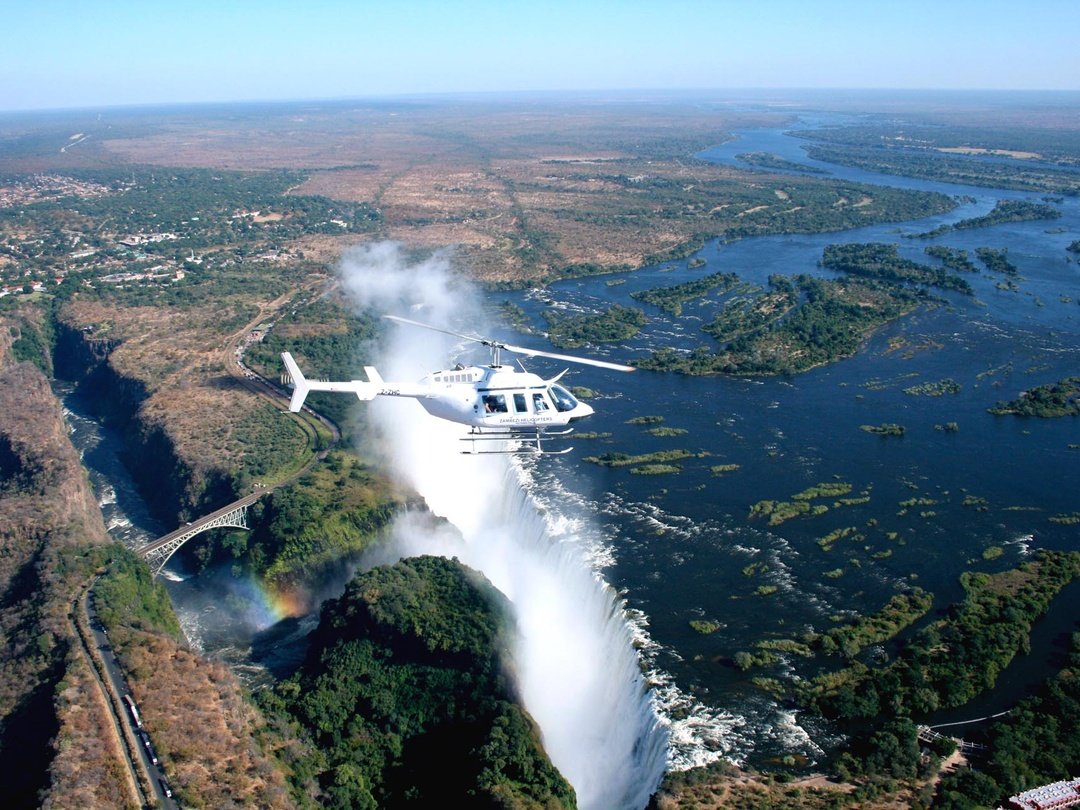 Tourists enjoying a 25-minute Victoria Falls helicopter tour with spectacular aerial views of Victoria Falls, the Zambezi River, Batoka Gorge, and surrounding wilderness.