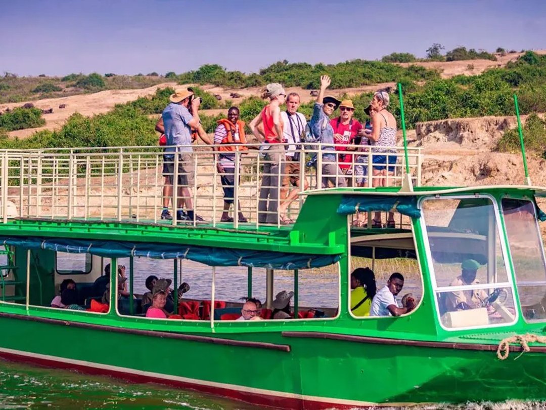Tourists enjoying a boat cruise on the Kazinga Channel in Queen Elizabeth National Park, Uganda while viewing wildlife and scenic landscapes