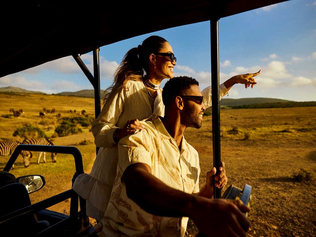 Honeymoon couple enjoying a romantic game drive safari experience in the African wilderness