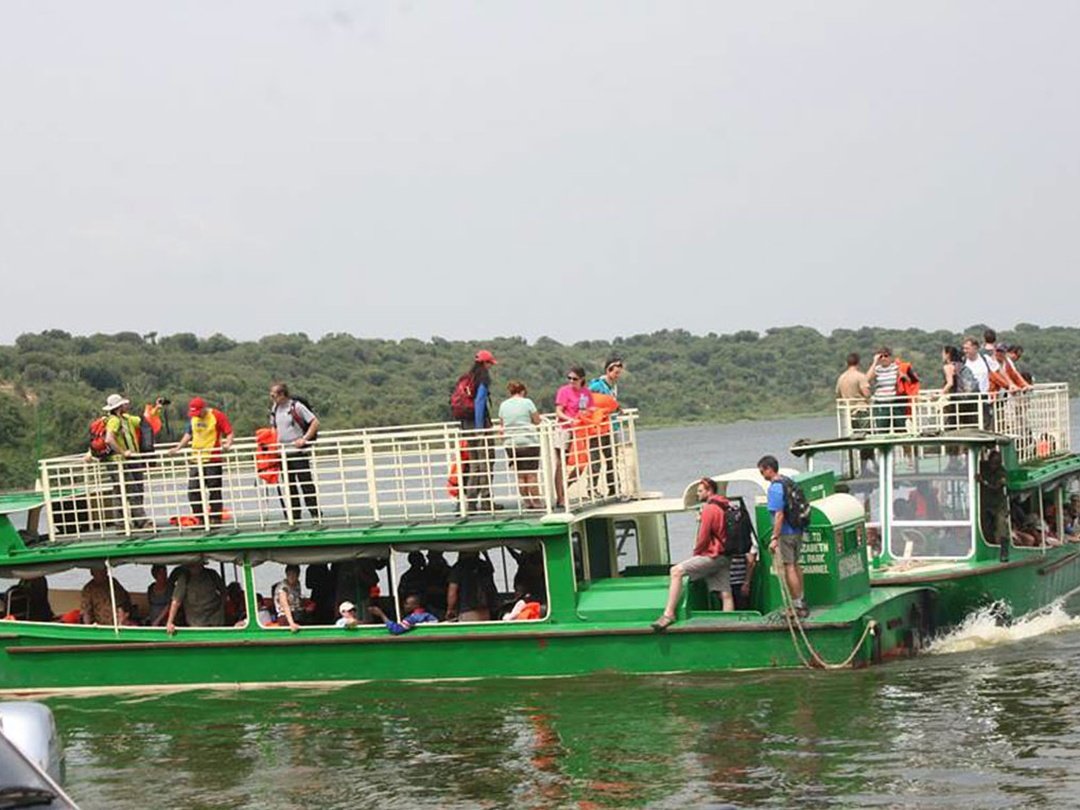 Tourists enjoying a boat cruise on the Kazinga Channel in Queen Elizabeth National Park, Uganda during the 5 Days Group Joining Uganda Safari wildlife experience.