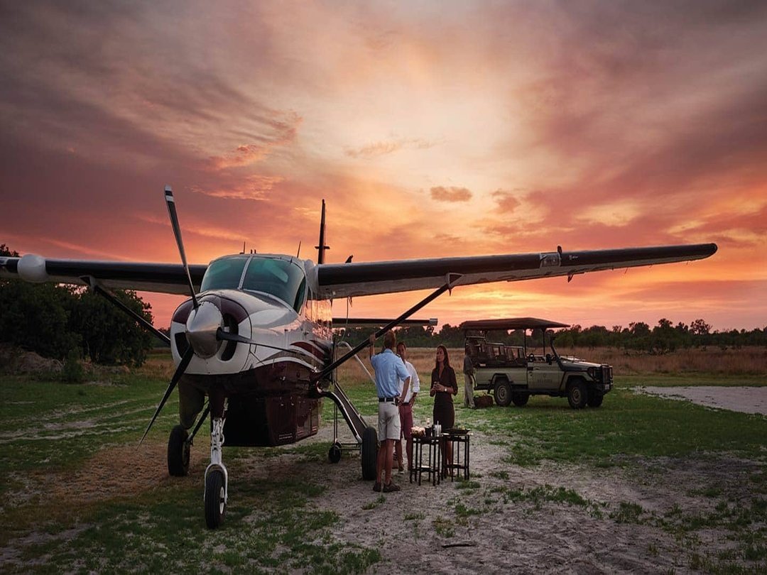 Fly-in tourists arriving at Moremi Game Reserve and transferring to a safari vehicle for a Botswana wildlife safari
