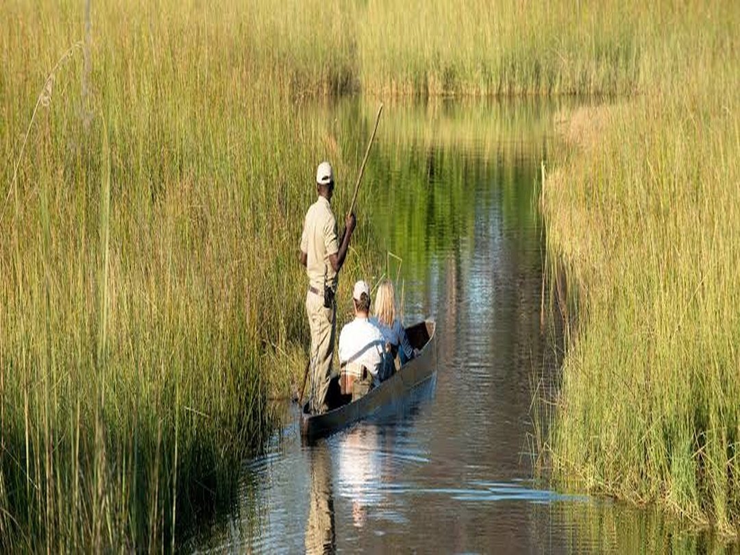 Tourists enjoying a mokoro safari through the waterways of the Okavango Delta in Botswana.
