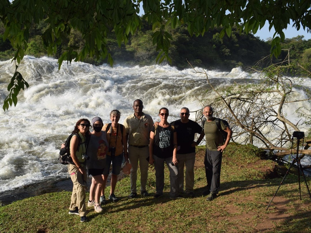 Tourists posing for a photo at Murchison Falls in Uganda during a group safari experience