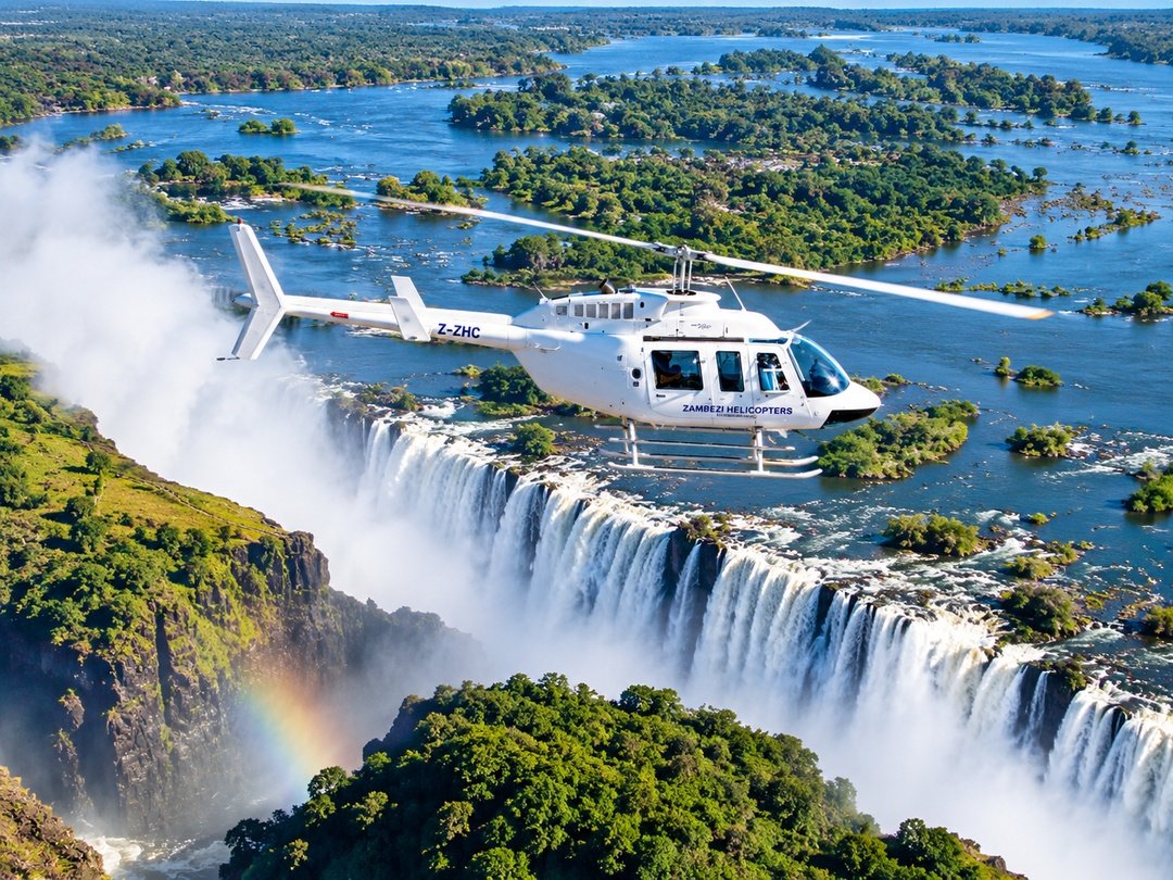 Couples enjoying a romantic Victoria Falls helicopter tour for honeymooners, with breathtaking aerial views of the waterfall, Zambezi River, gorge, and surrounding landscape.