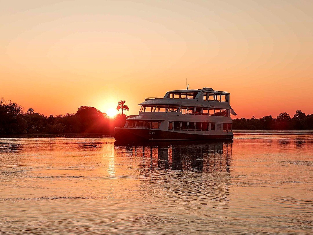 Tourists enjoying beautiful sunset views on the Zambezi River during a relaxing river cruise near Victoria Falls