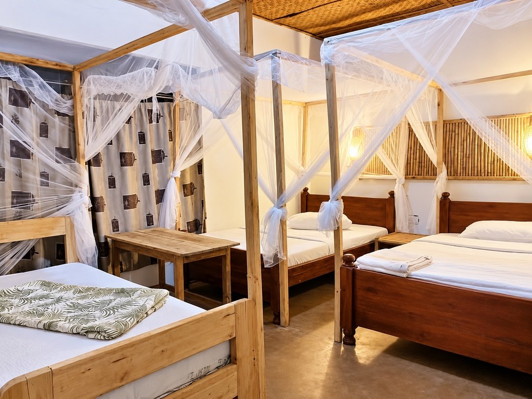 Room at Little Monkey Camp, a budget lodge near Kibale National Park with comfortable beds and mosquito nets for chimpanzee trekking travelers.